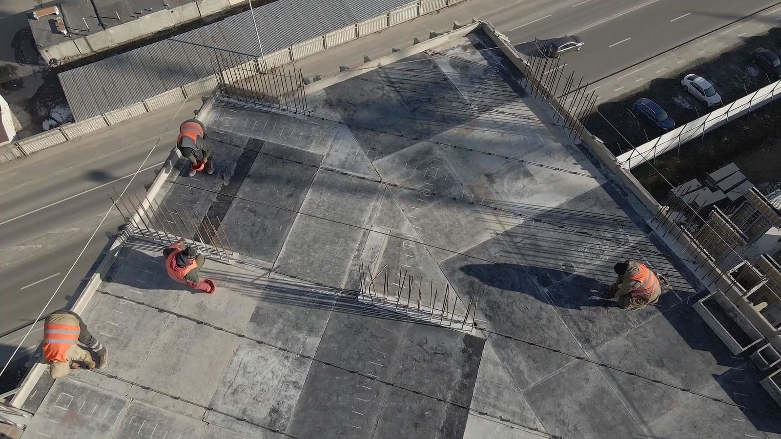 Operai al lavoro sul solaio di copertura di un edificio, visti dall'alto