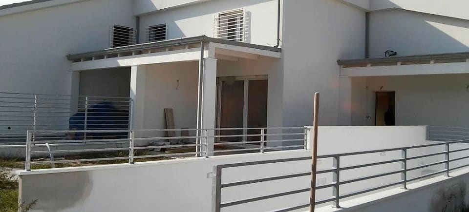 Villetta bianca finita con portico e ringhiere in metallo