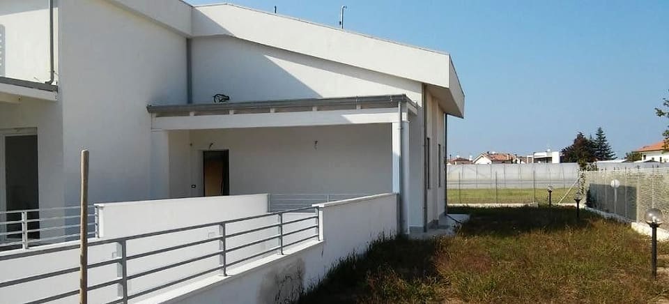 Villetta bianca con terrazzo e ringhiera, vista laterale