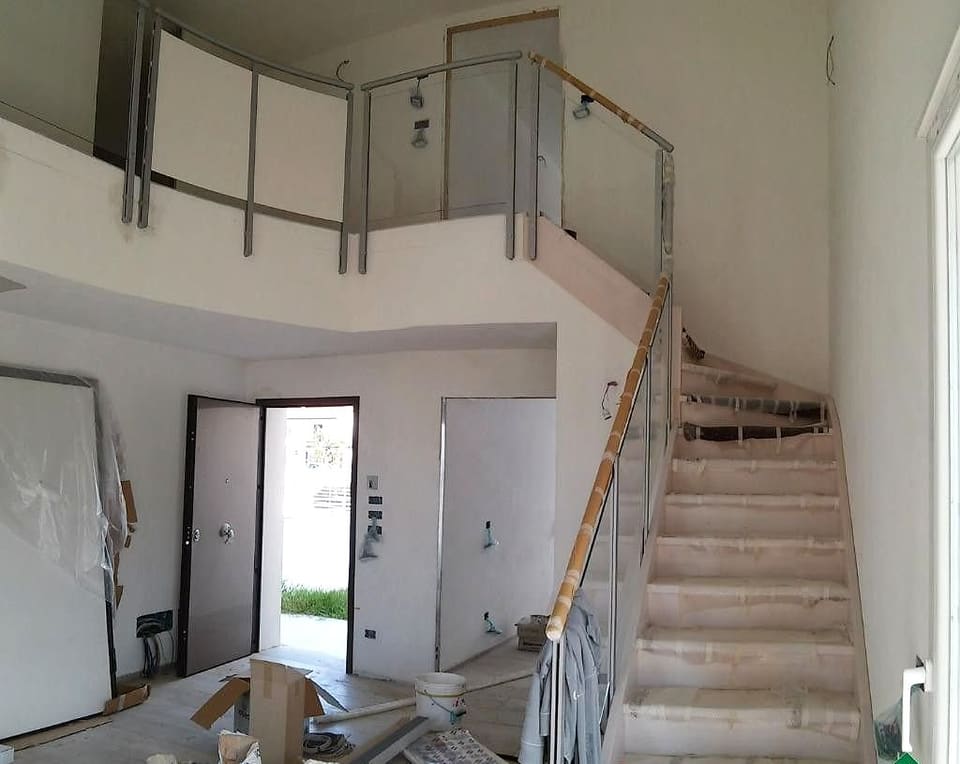 Ingresso con scala in costruzione e parapetto in acciaio e legno